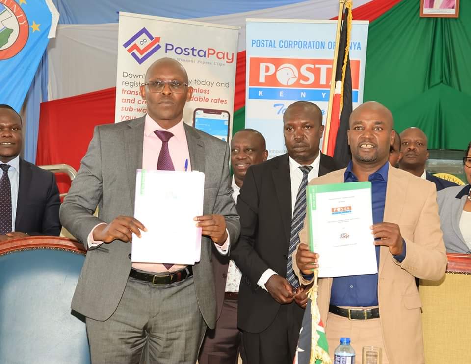 Bomet Governor Hillary Barchok (in Cream-Yellow suit) and Postal Corporation of Kenya Post Master General and Chief Executive Officer John Tonui Posing after signing a memorandum of Understanding (MOU at the county headquarters.