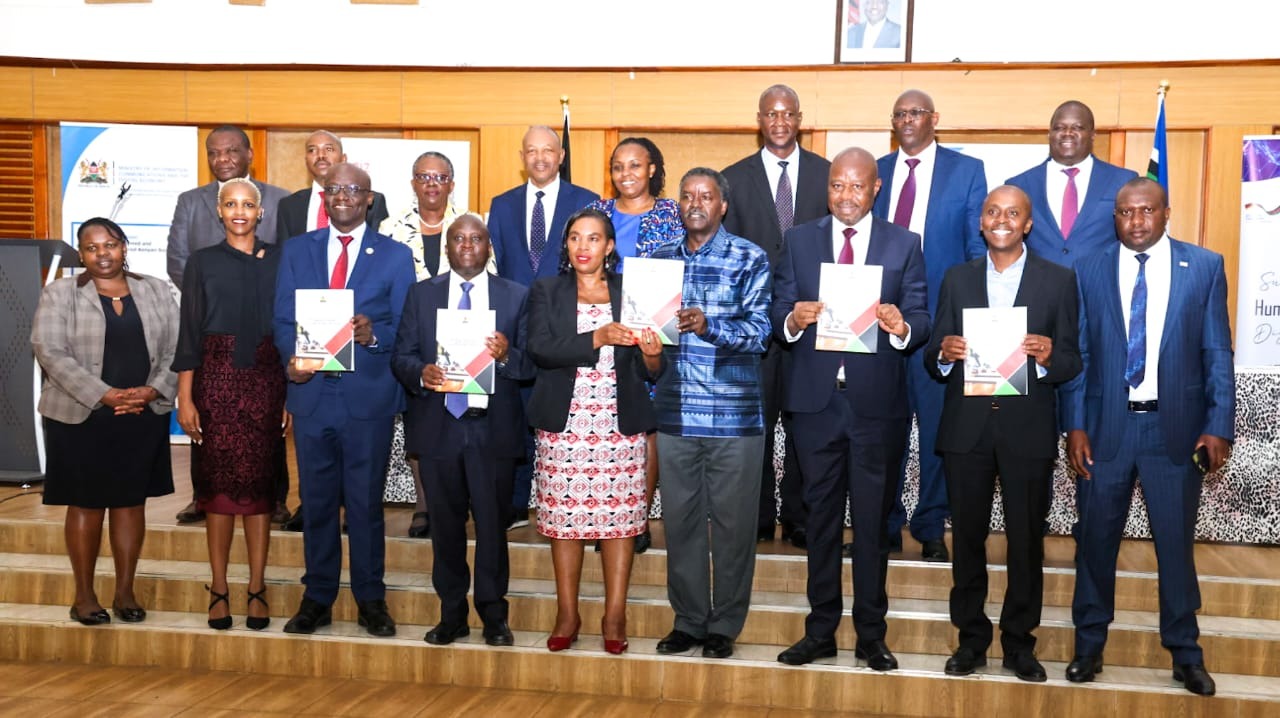 he Cabinet Secretary, Ministry of Information, Communications and the Digital Economy (MICDE), Dr. Margaret Ndung’u (fifth left) flanked by ICT and Digital Economy Principal Secretary Eng. John Tanui , Sector Working Group (SWG) Chairperson Prof. Timothy Waema (right) and the Principal Secretary for Broadcasting and Telecommunications Prof. Edward Kisiang’ani during the handover ceremony of the ICT SWG Final Report. Photo by Beverlyne Musili.