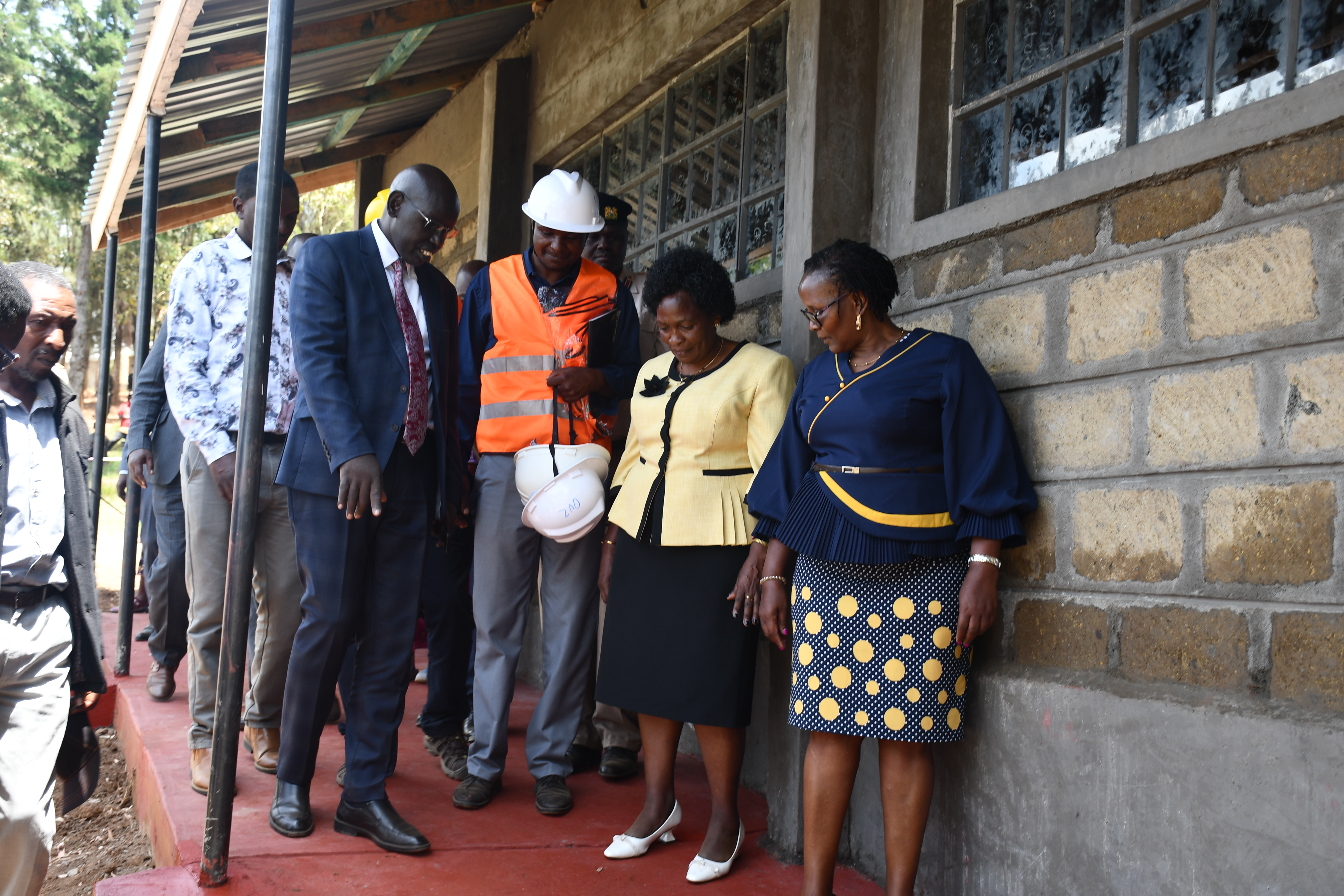 Principal Secretary, State Department for Basic Education, Dr. Belio Kipsang (left) at Sulgwita primary in Turi, Molo sub-county to inspect the construction progress of grade nine classes.