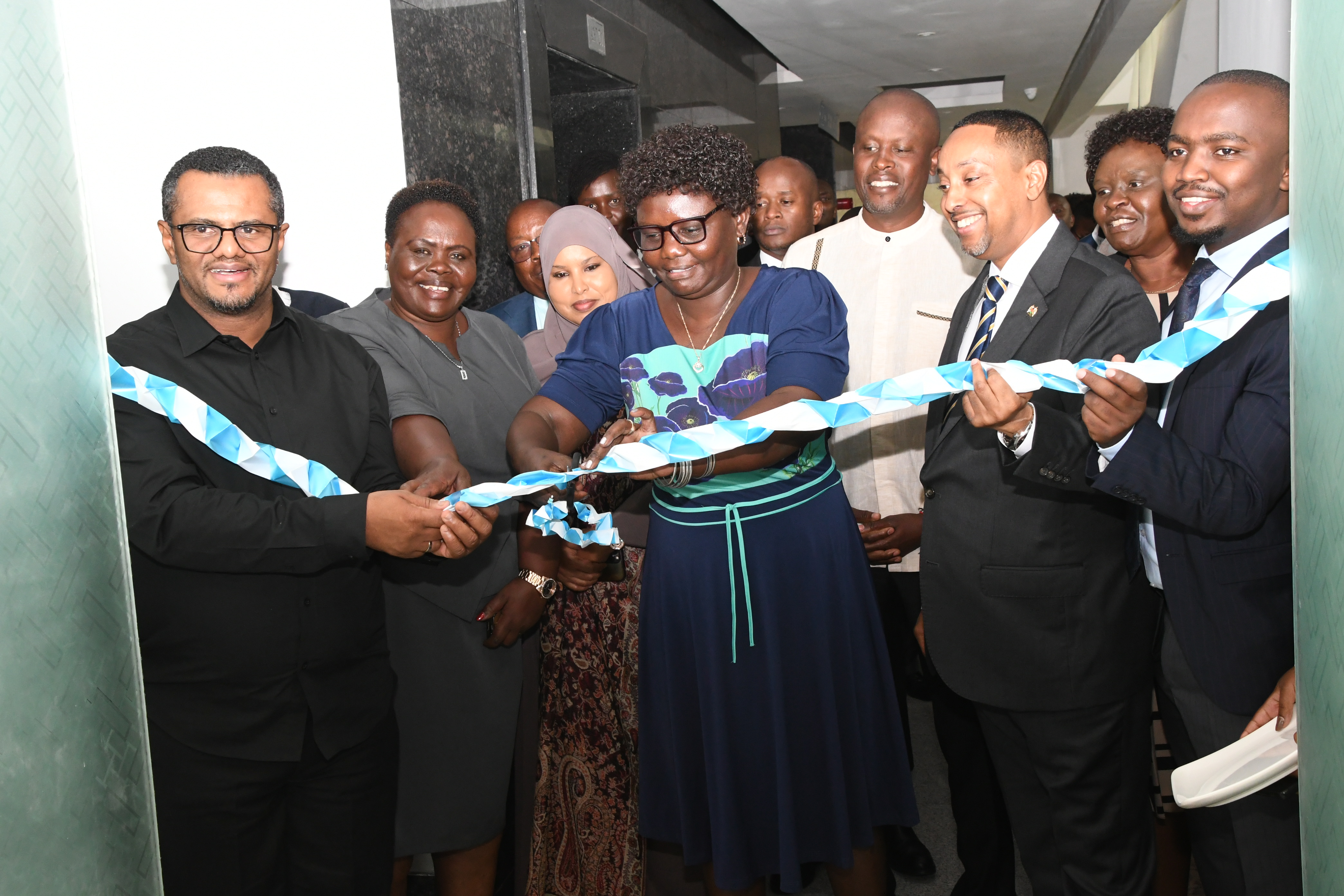 East African Community Affairs (EAC), the ASALs and Regional Development, Cabinet Secretary Beatrice Moe (center) cuts a tape at Hazina Towers Nairobi during the official handing over of new offices for East African Legislative Assembly (EALA) members, Kenya Chapter. Photos/ Bonface Malinda