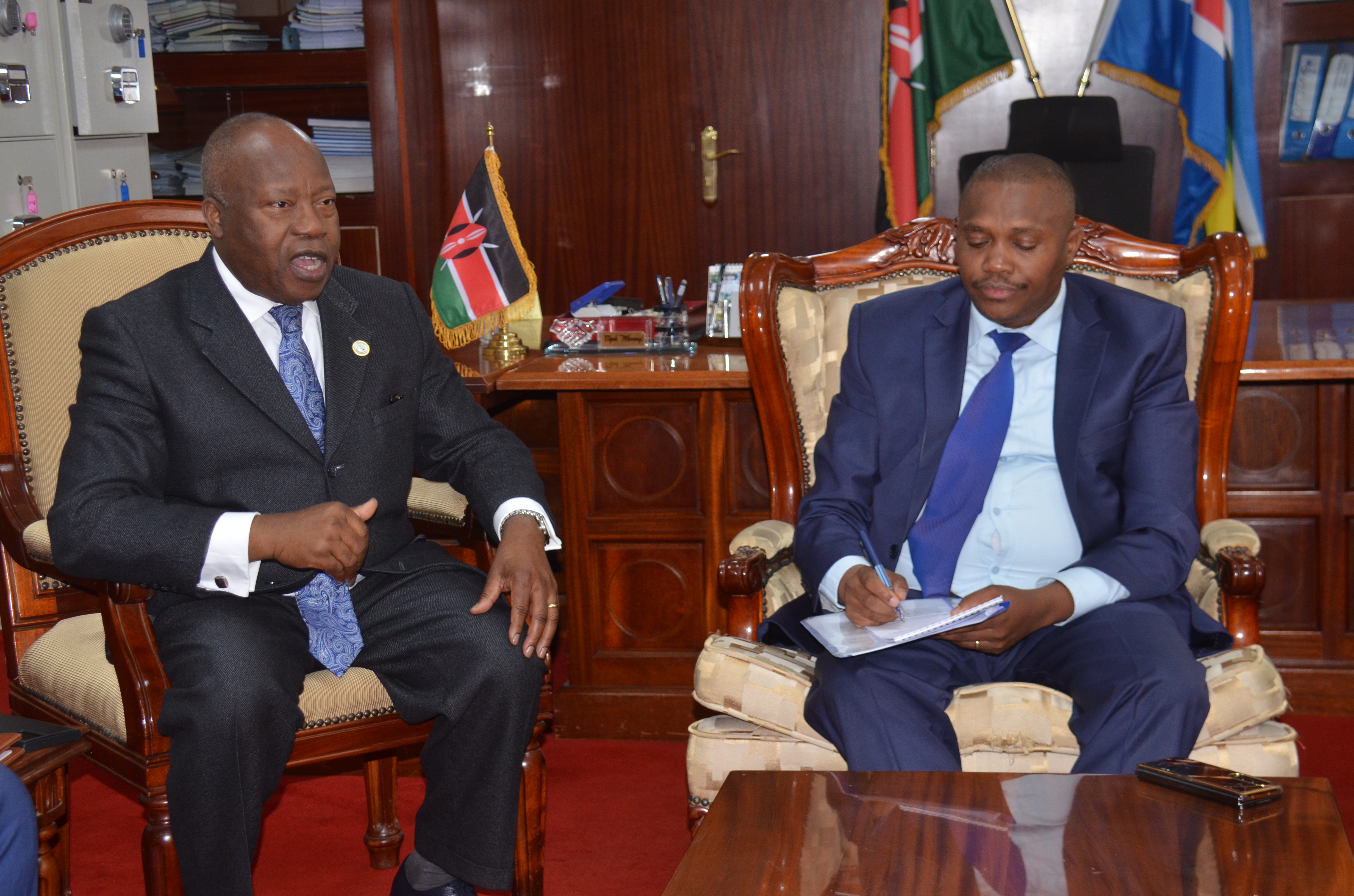 The Executive Secretary for ICGLR Ambassador Joao Samuel Caholo (l) with Mining Principal Secretary Elijah Mwangi (r) during their meeting in Nairobi.