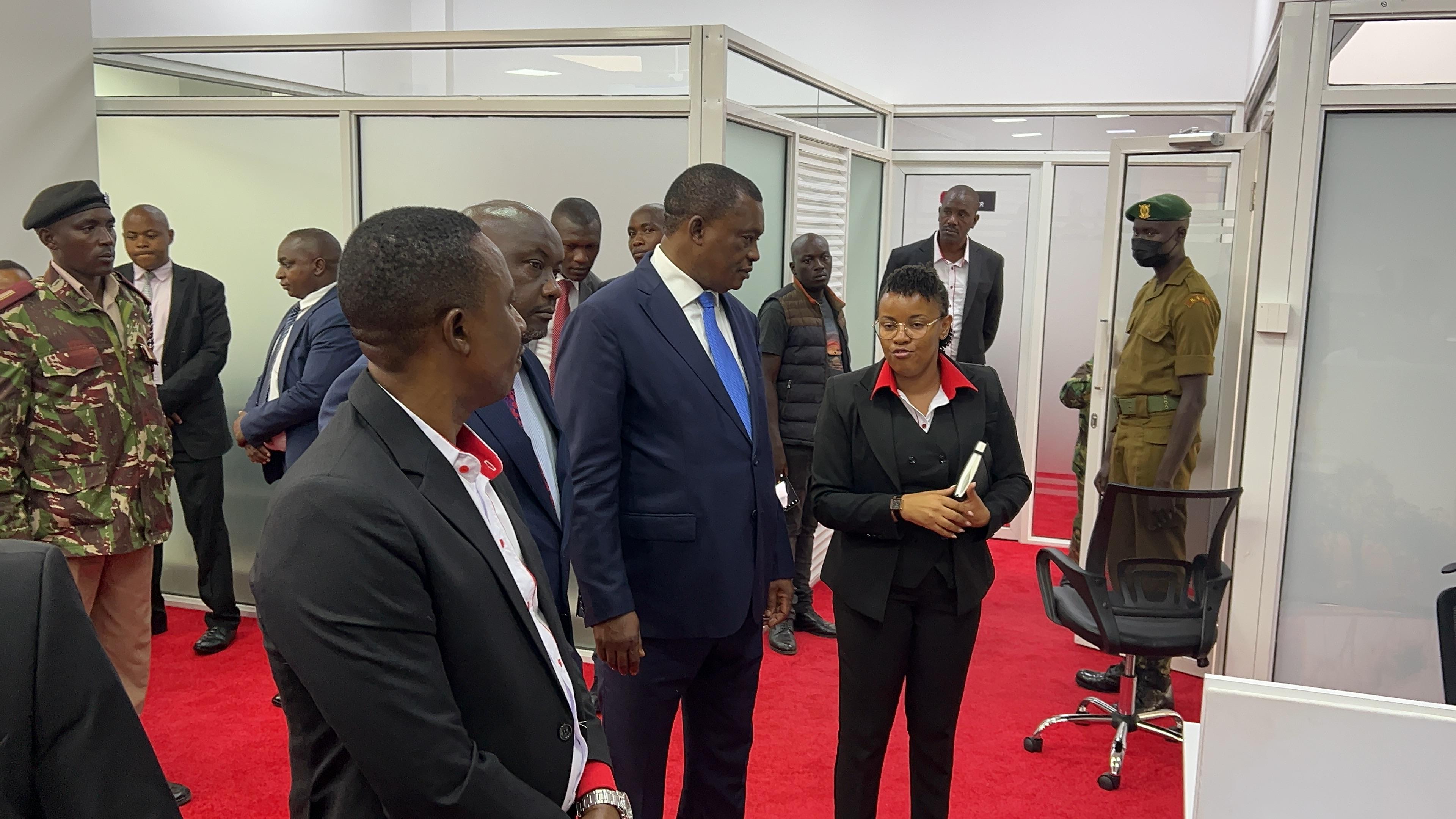 Cabinet Secretary (CS) for Public Service and Human Capital Development Hon. Justin Muturi (Centre) consults with a Huduma center staff during his inaugural visit to Huduma Kenya Secretariat Offices, Huduma Contact and Tele-Counselling Centre and Huduma Centre GPO in Nairobi.