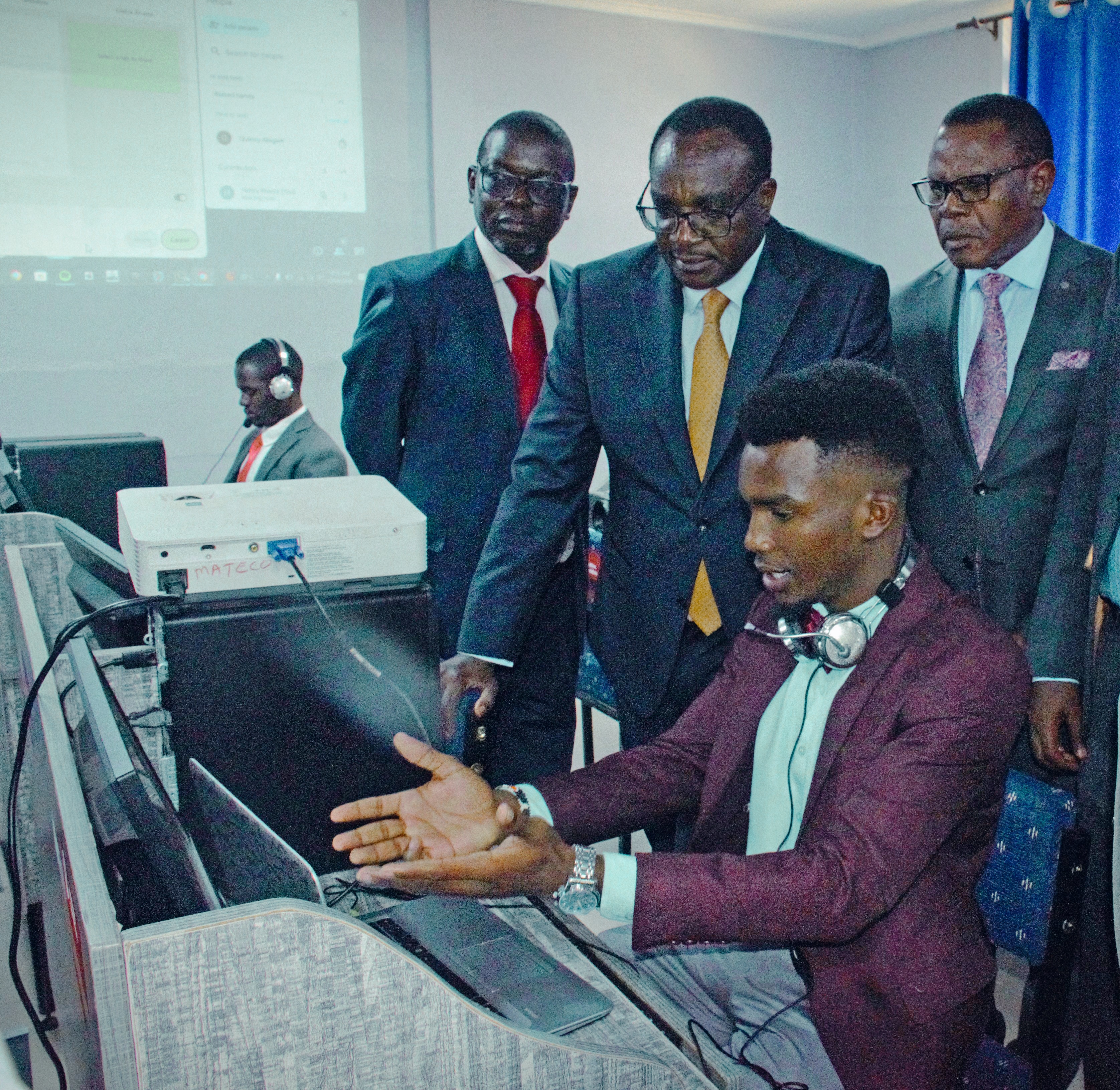 Henry Kivuva, a student at the Machakos Teachers College, takes Education Cabinet Secretary Julius Ogamba through a digital session with their new advanced computers during the launch of the Scaling Digital Skills program at the Machakos TTC. Photo by Steve Allan