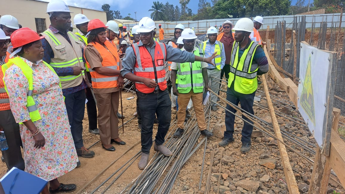 One of the Engineers showing the Principal Administrative Secretary Juliana Yiapan (L) some of the achievements they have had with the Affordable Housing Project at Lumumba site, Kisumu Central. Photo/Joseph Ouma