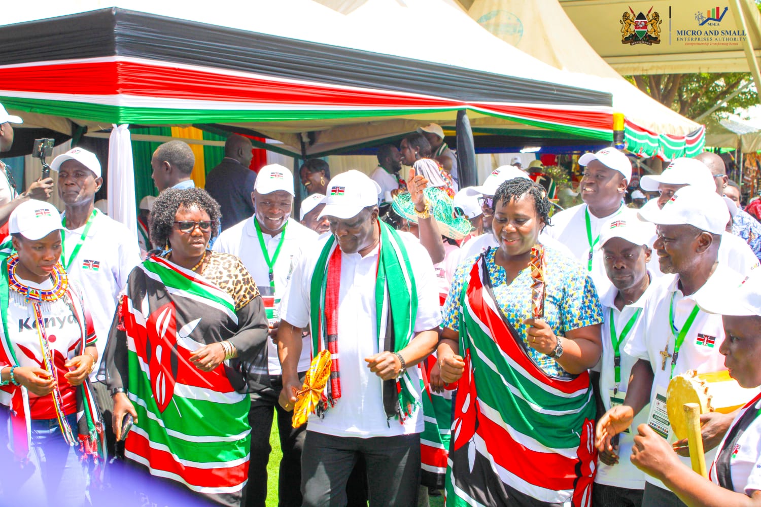 Cooperatives and MSMEs CS Wycliffe Oparanya (in white cap) joins Kenya exhibitors for a dance in Juba, South Sudan.