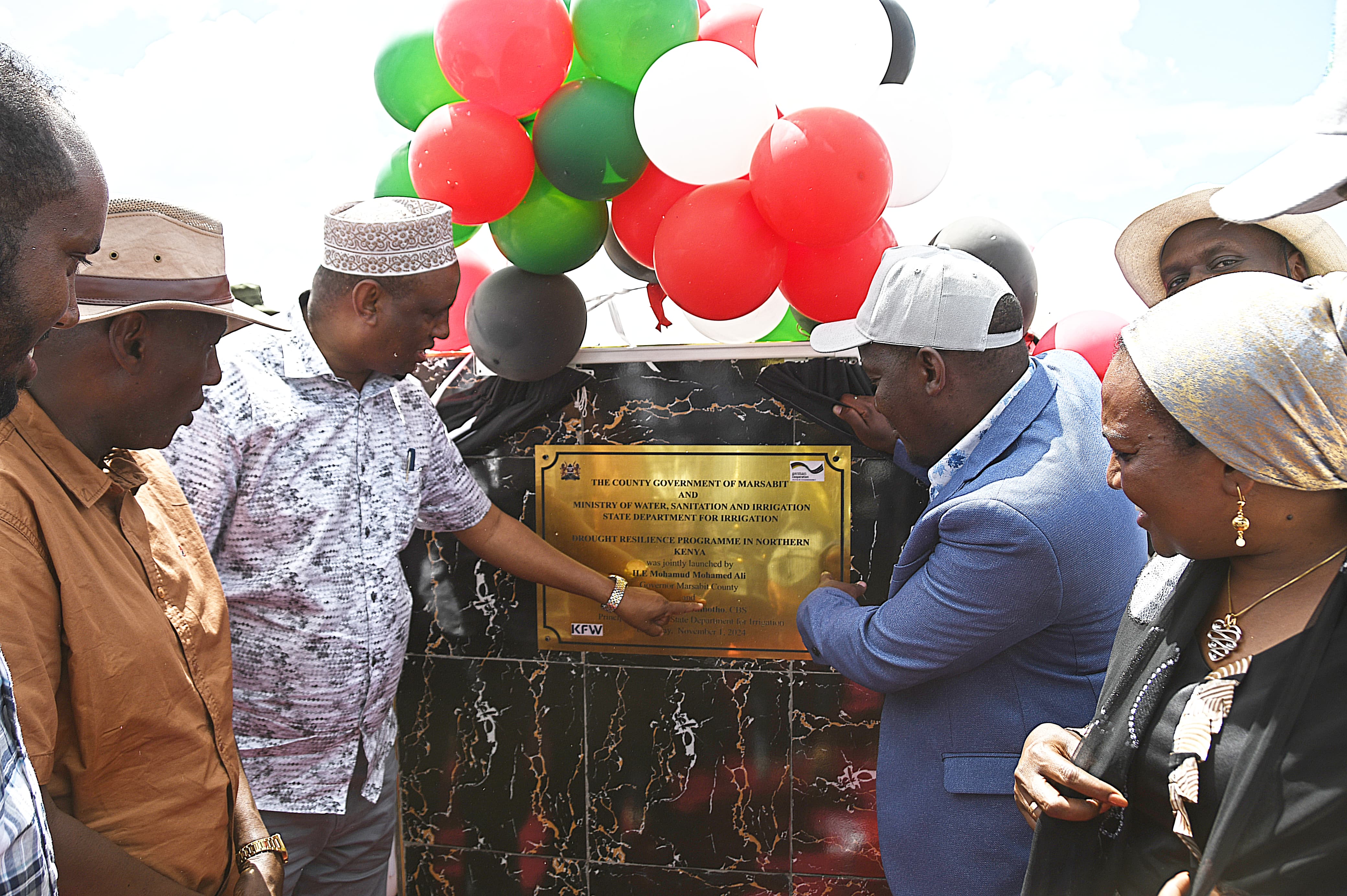 The principal secretary for irrigation CPA Ephantus Kimotho (grey coat) and Marsabit governor Mohamud Ali unvail the plaque during the launch of the Drought Resilience Programme in Northern Kenya (DRPNK) at Bambala-Fachana in Sololo Sub-County.