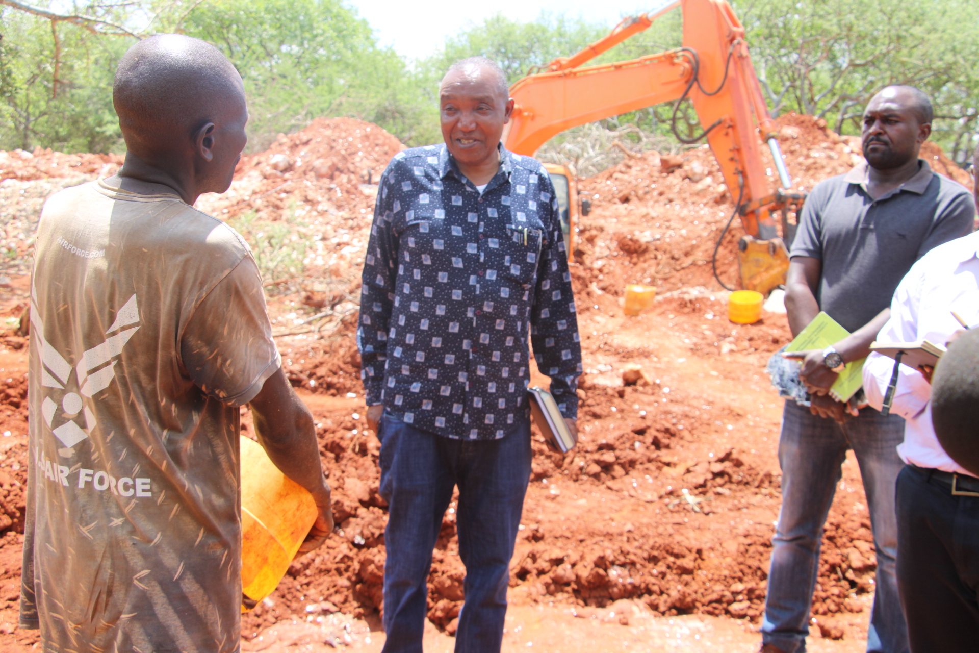 Director mines, Gregory Kituku (in checked shirt) talking to miners of mica belonging to Apple Mining Group in Kishushe. 