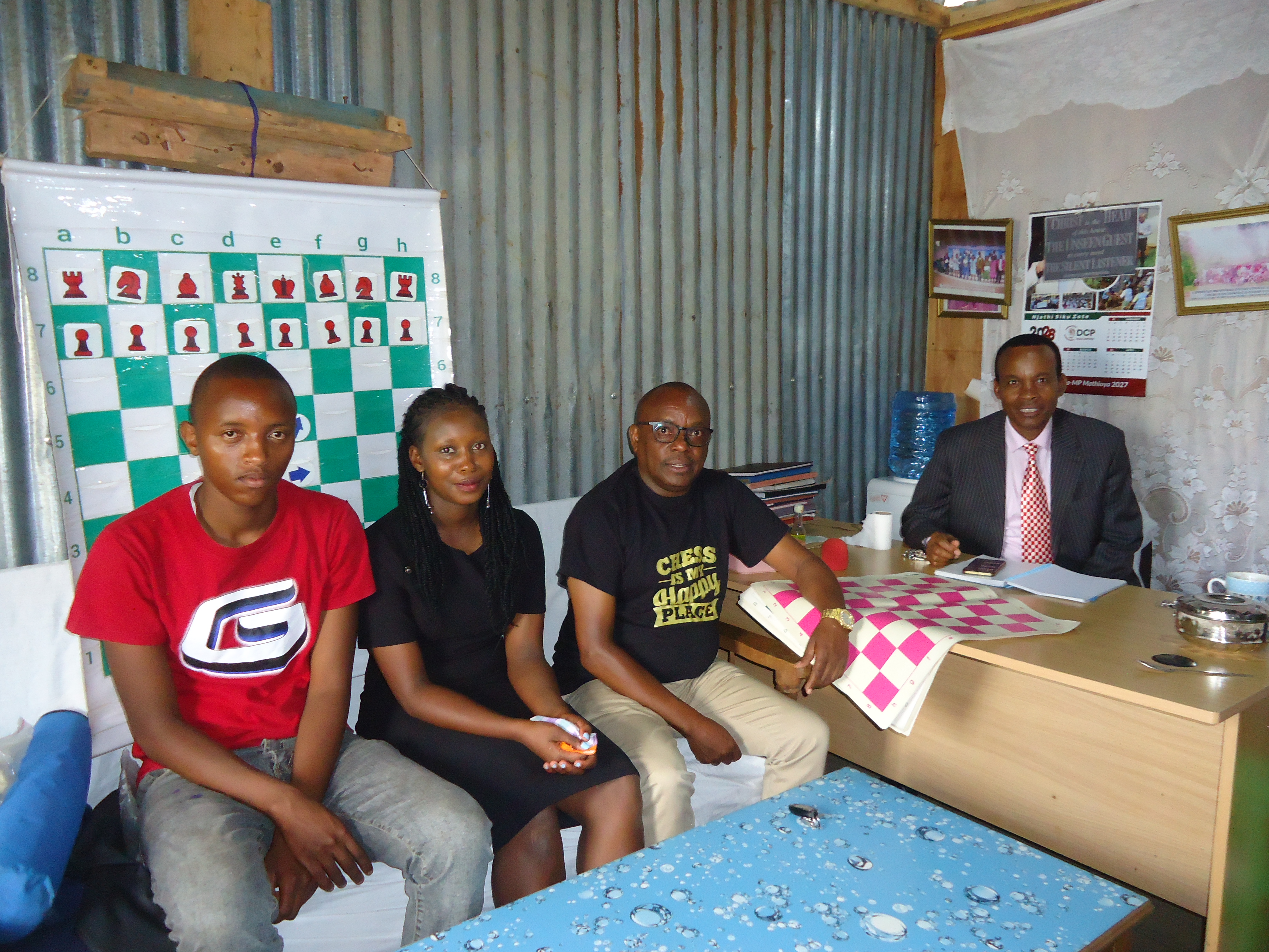Chess player Jane Wangari (centre) poses with fellow player Stephen Gachuhi, (left) and their trainer, Josephat Kimani, (second right) Founder and Director of Chess Masters Club. PHOTO: ESTHER MBUTHIA