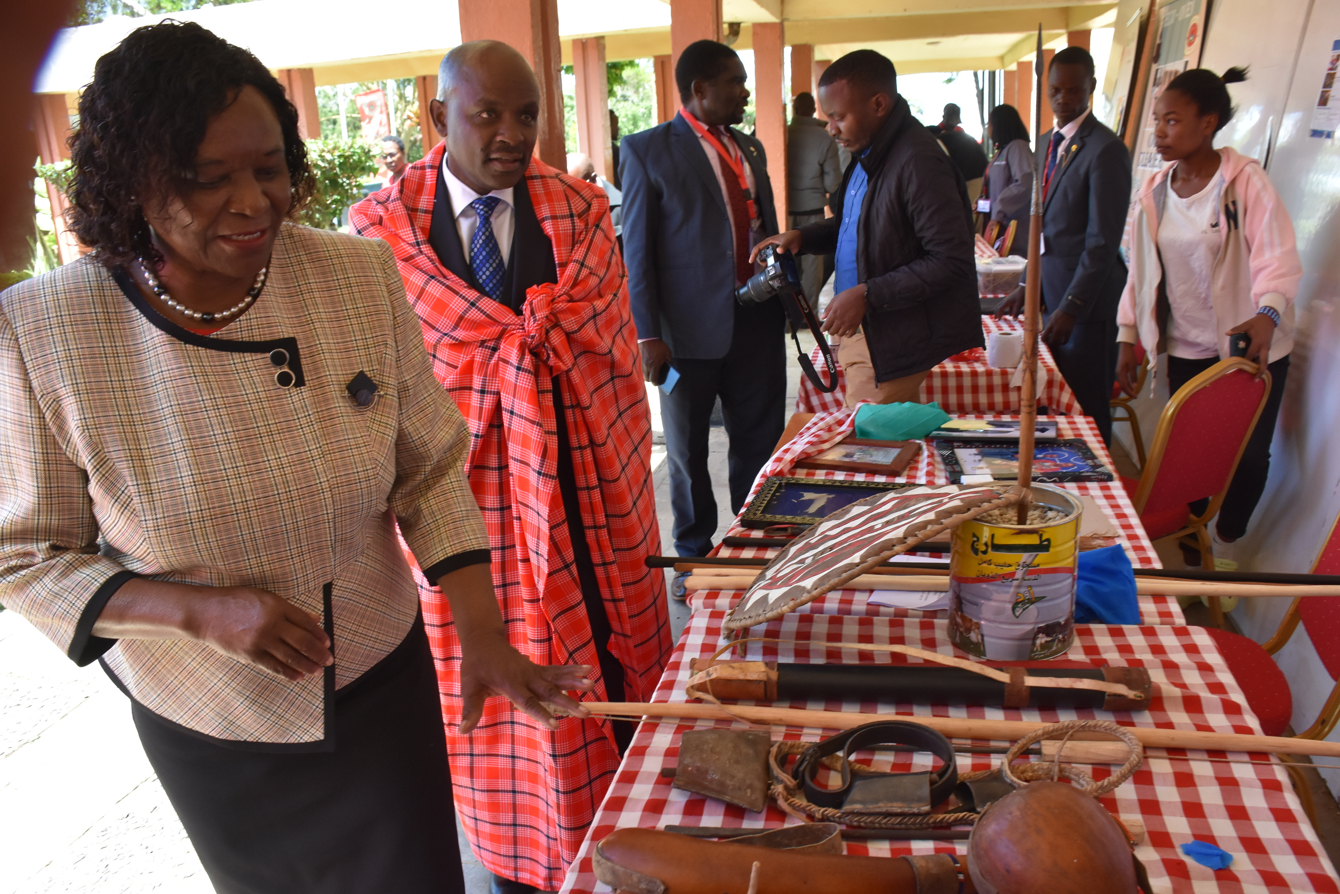 Maasai Mara University Vice Chancellor Prof. Peninah Oloo, left and KNIA CEO Dr. Tonny Omwansa, in a Maasai shuka in one of the students’ stands showcasing their innovative ideas during the Innovation week held at the Narok town campus, Narok Central Sub-County