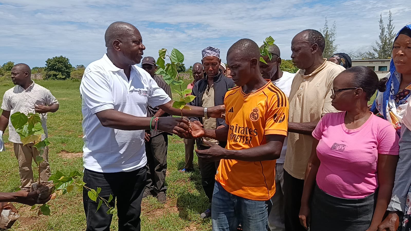 Chairman of the Agriculture Food Authority (AFA) Cornelly Serem (left) distributing cotton seedlings to farmers during an agricultural support initiative in Kwale.