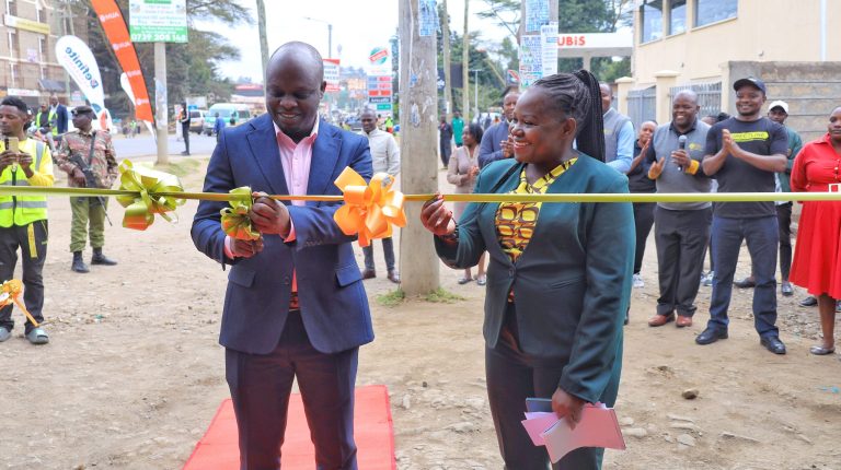 Narok County, Deputy Governor, Tamalinye Koech (left) cuts ribbon to officially open the Insurance Open Day at the William Ole Ntimama Stadium as Insurance Regulatory Authority, Corporate Communications and PR Deputy Director, Joanne Wanjala (right) looks on.