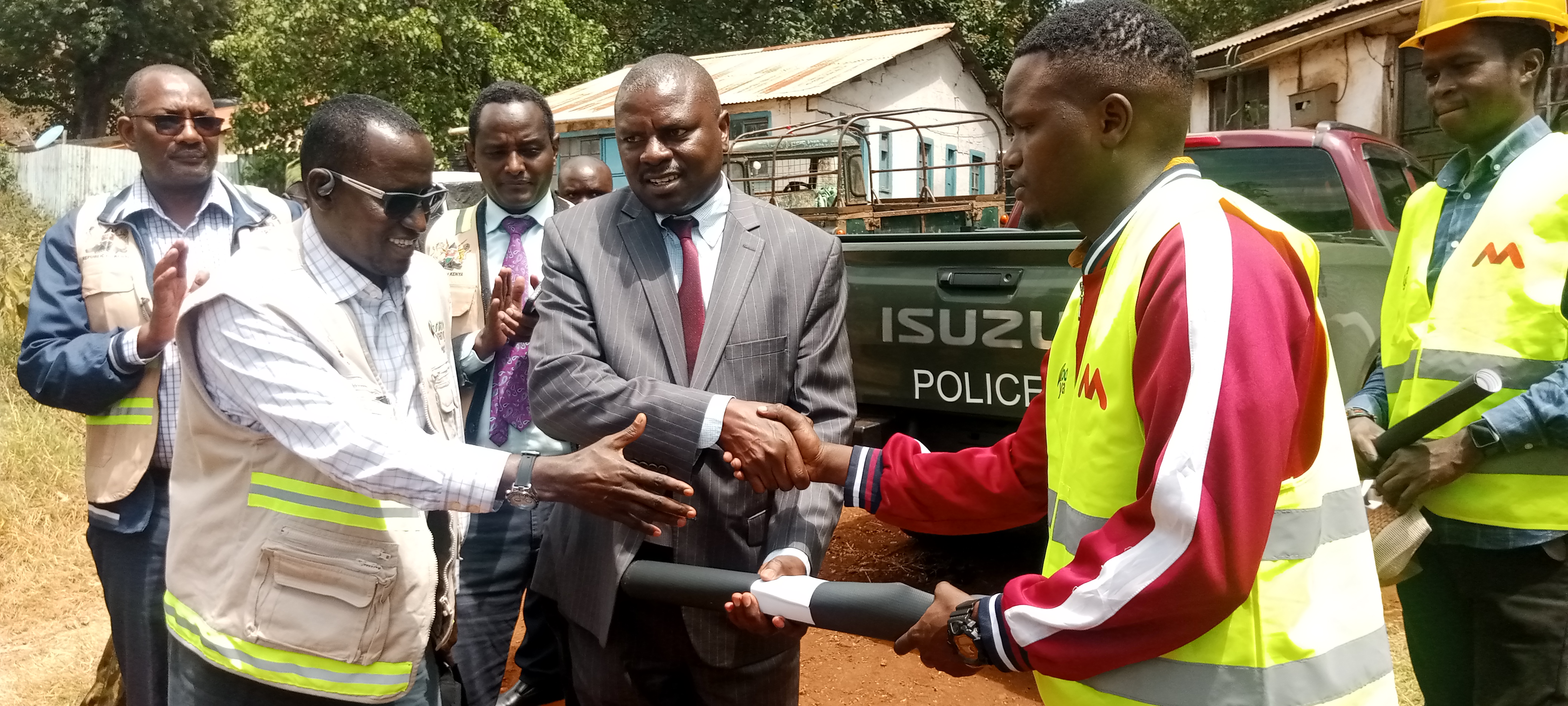 An official from Mankos Agencies Limited, Eng. Dennis Korir, receives An official from Mankos Agencies Limited, Eng. Dennis Korir (Right), receives construction site documents for the affordable housing project in Marsabit town from County Commissioner Stanley Kamande (Centre). .PHOTO: SEBASTIAN MIRITI