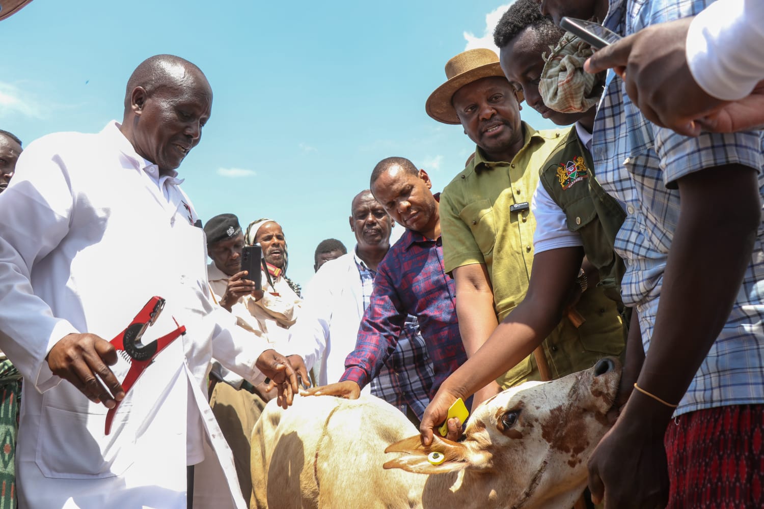Agriculture and Livestock Cabinet Secretary Mutahi Kagwe (second right) with livestock farmers in Karawa village, Tarasaa Sub-County in Tana River, during the official launch of the ANITRAC system. 