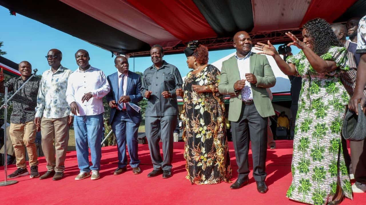 Prime Cabinet Secretary Musalia Mudavadi and CS Diaspora Affairs (middle), Kakamega County Governor Fernandes Barasa (second right) and other senior government officials jig during the launch of the second disbursement of the National Youth Opportunities Towards Advancement (NYOTA) Programme in Kakamega town. (Photo by Cypron Esolio, KNA)