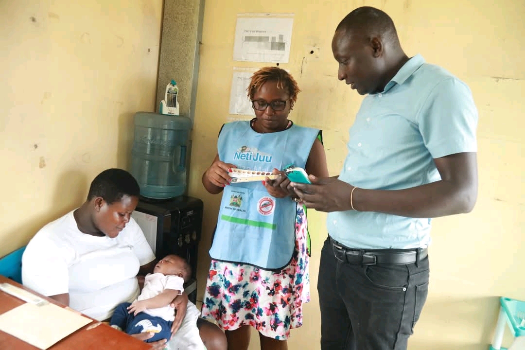 Kevin Kasadhe (right) demosntrates how the Bili Ruler works to a nurse at Jaramogi Oginga Odinga Teaching and Referral Hospitalon 