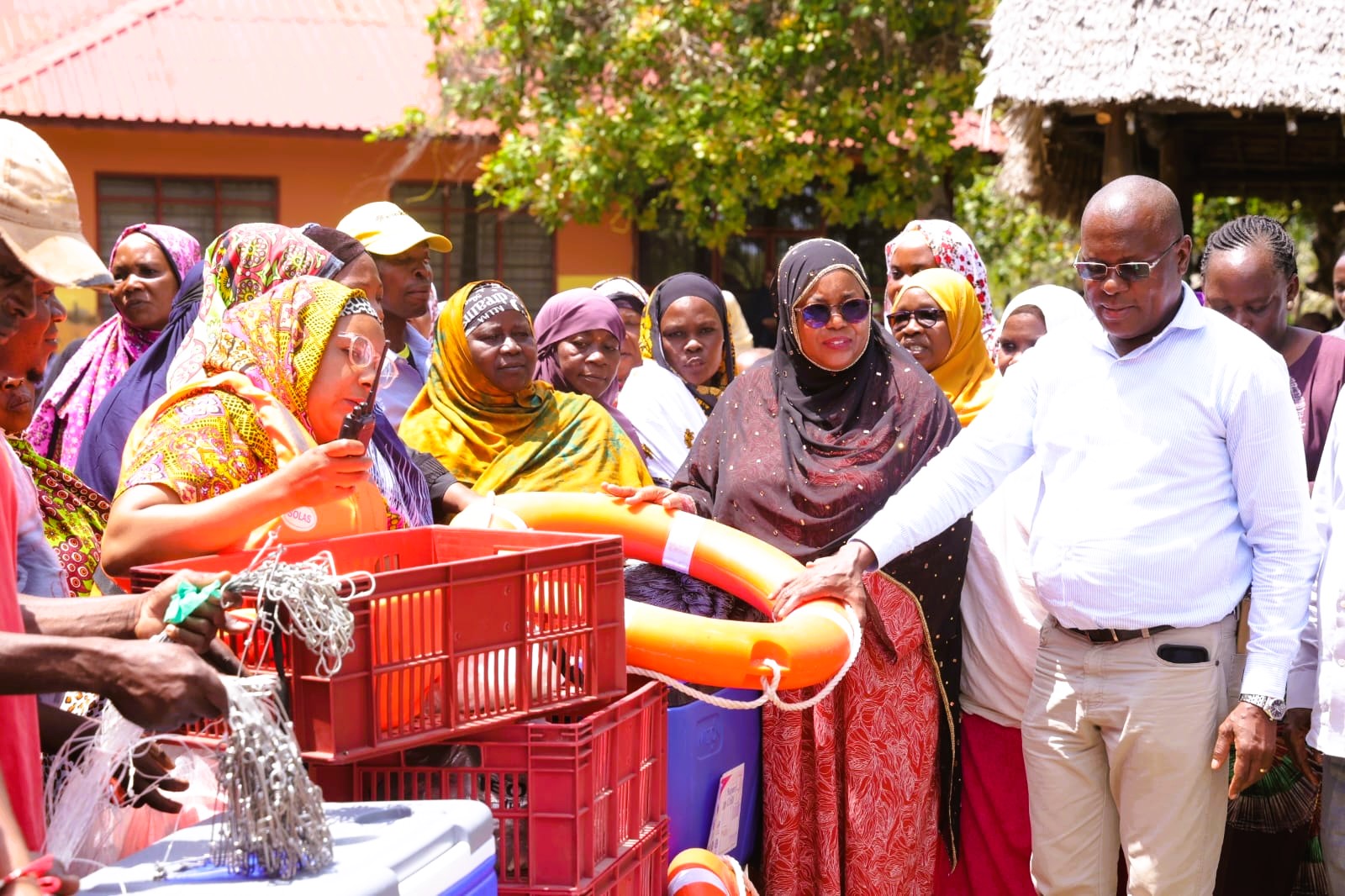 Governor Fatuma Achani (C) flanked by County Executive for Agriculture and Fisheries Roman Shera (L) when she distributed fish cooling facilities to local self-help groups in the Mwazaro area of Msambweni sub county.
