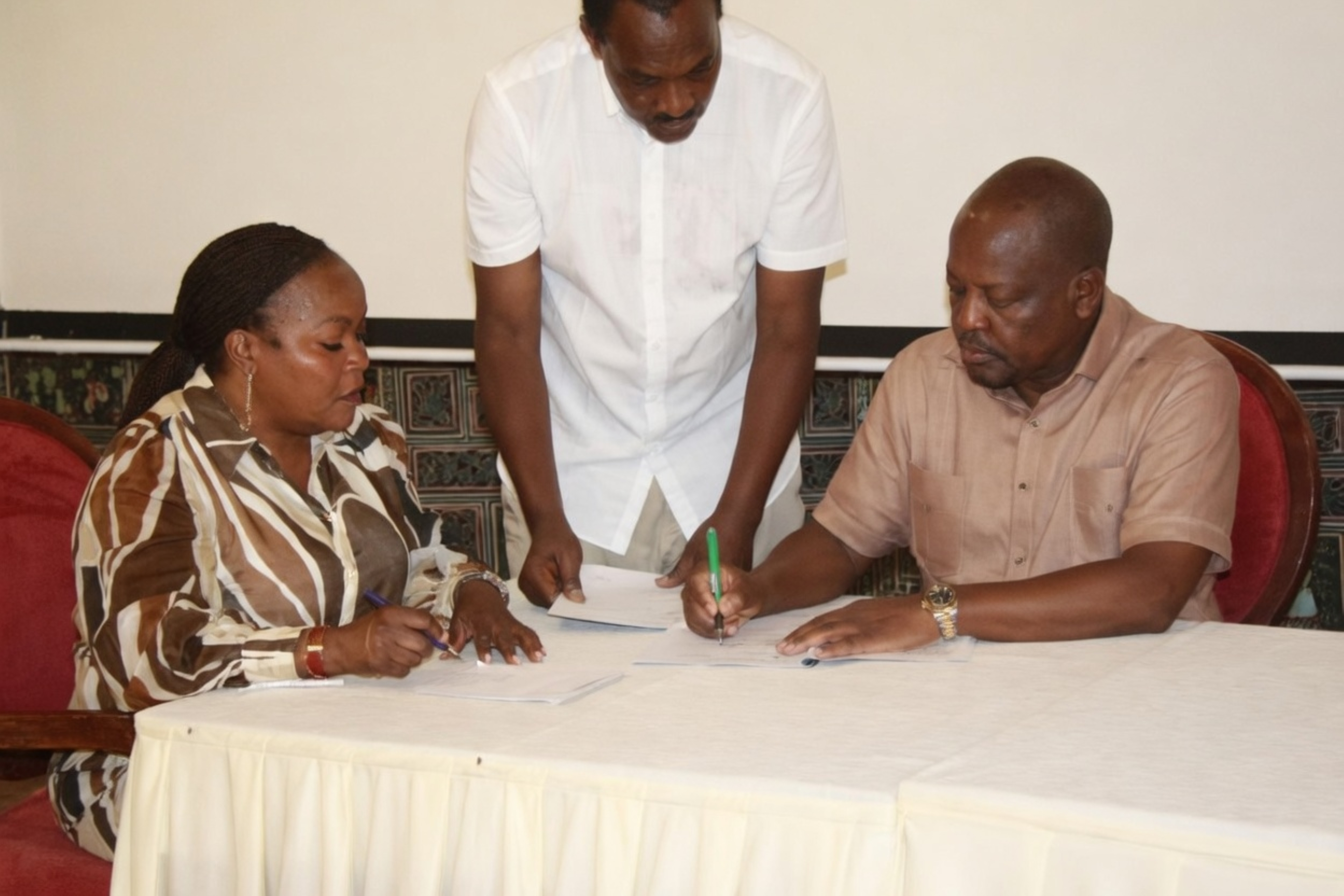 Kenya Seed Company Chairperson Purity Ngirici signs (left) signs a performance contract for her company with Agriculture Cabinet Secretary Mutahi Kagwe at a Malindi