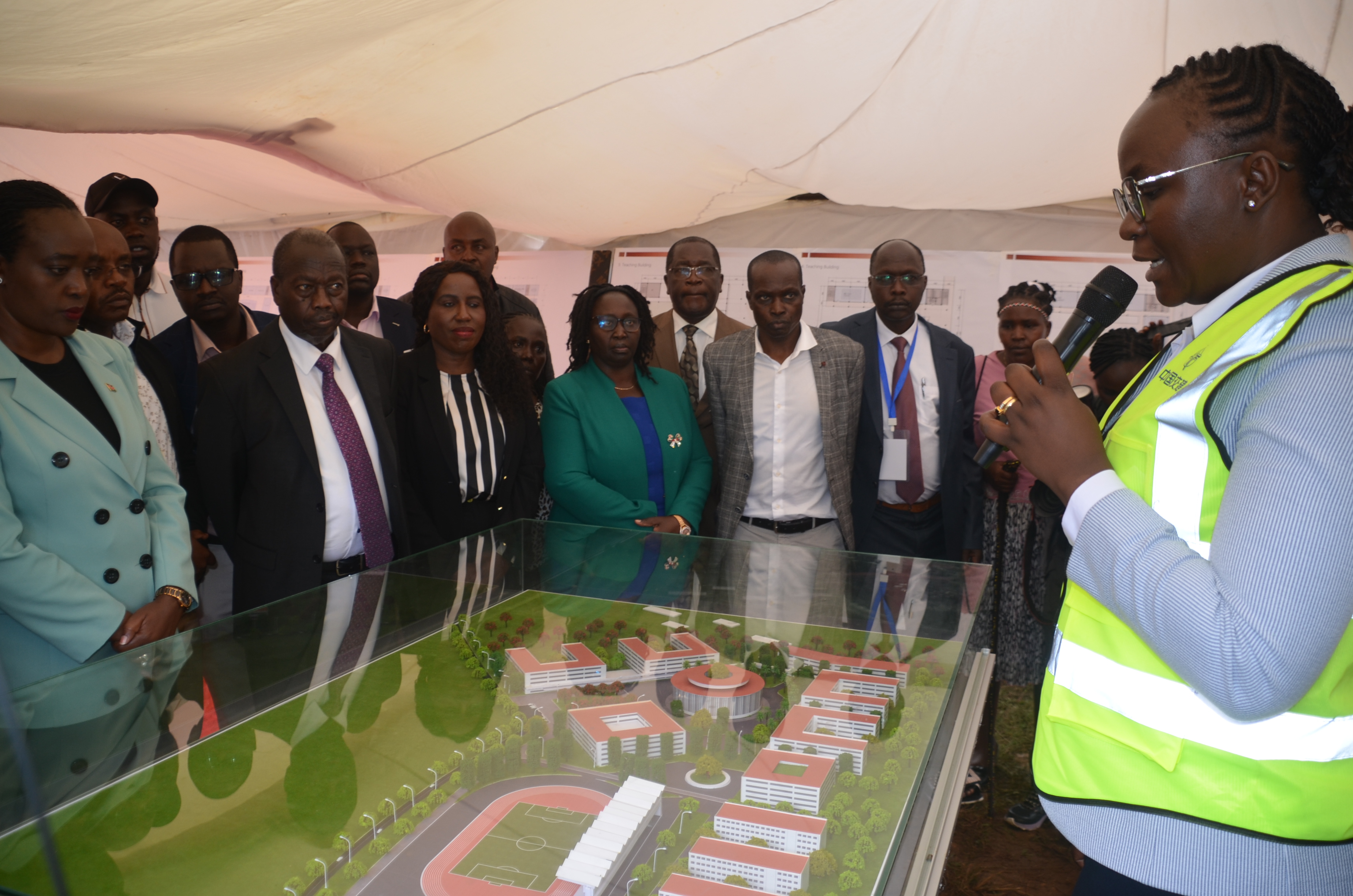 Defense Cabinet Secretary Soipan Tuya (left) is taken through the Kabarnet University College design model during the groundbreaking ceremony at the main campus grounds.