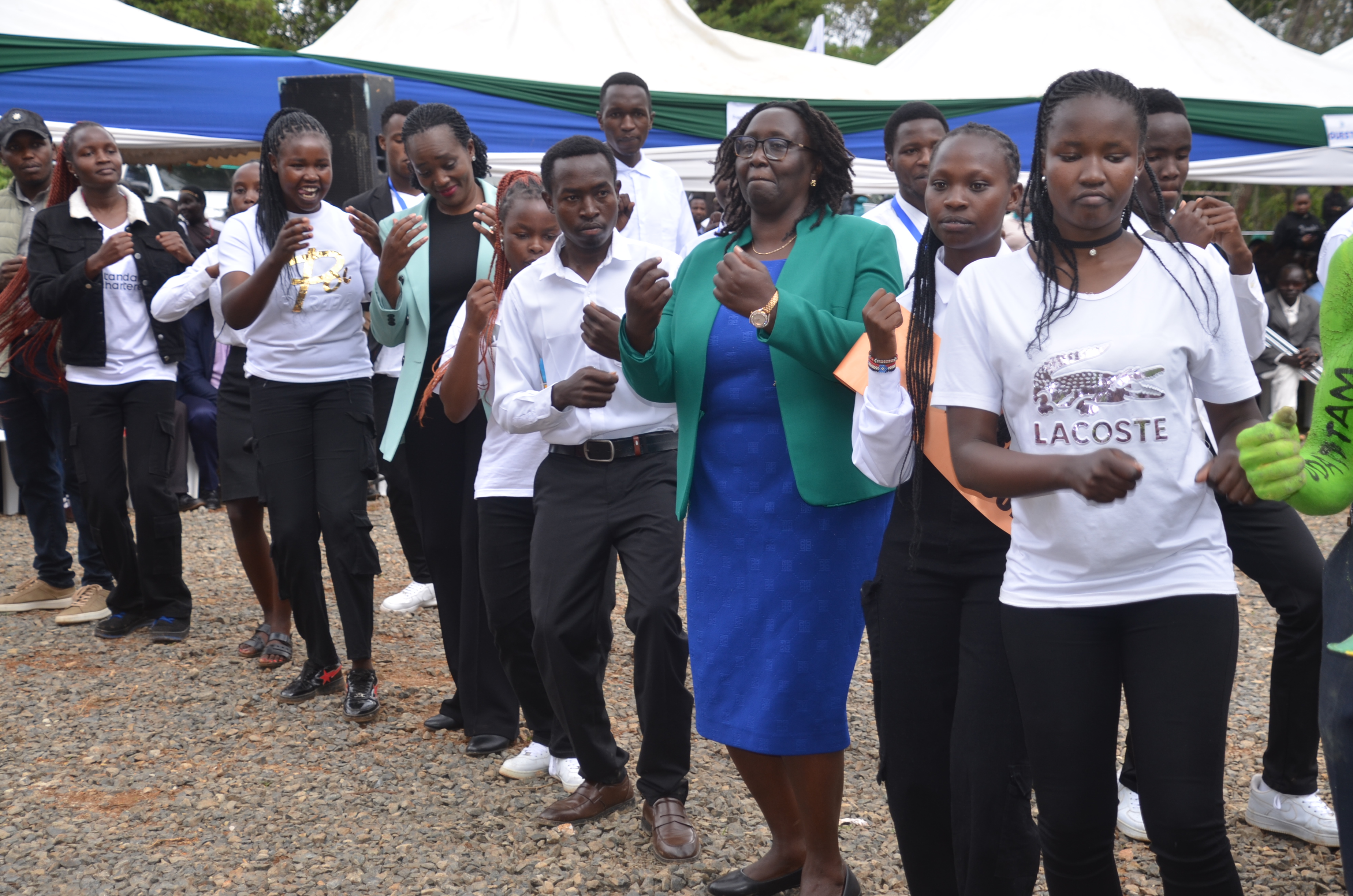 Gender Cabinet Secretary Hanna Cheptumo joins Kabarnet University College students in song and dance during the ceremony at the main campus grounds.