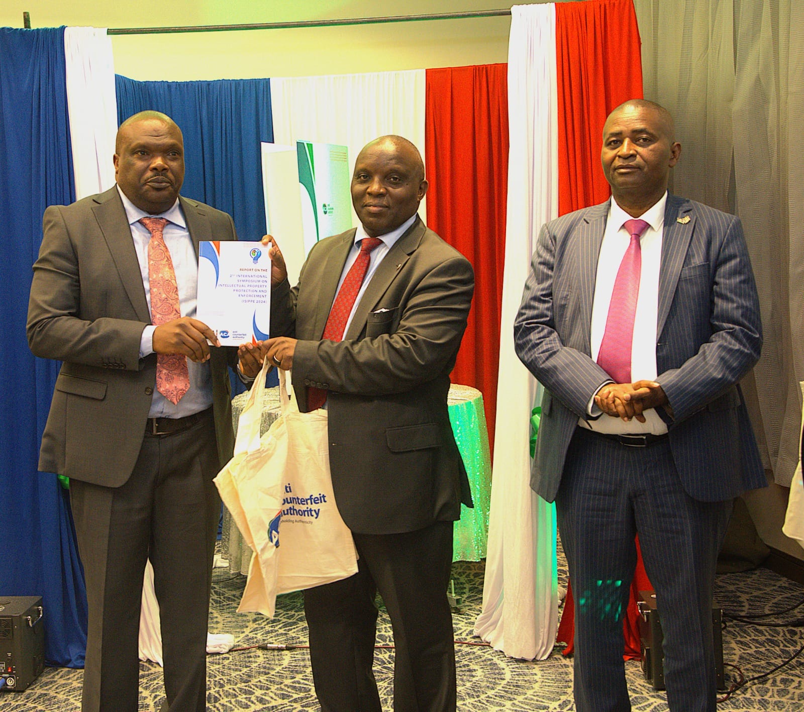Industrialization Secretary Prof. Erastus Gatebe officially hands over the Report on the Second International Symposium on Intellectual Property Protection and Enforcement ISIPPE-2 to the Executive Director, Anti-Counterfeit Authority Dr. Robi Mbugua Njoroge