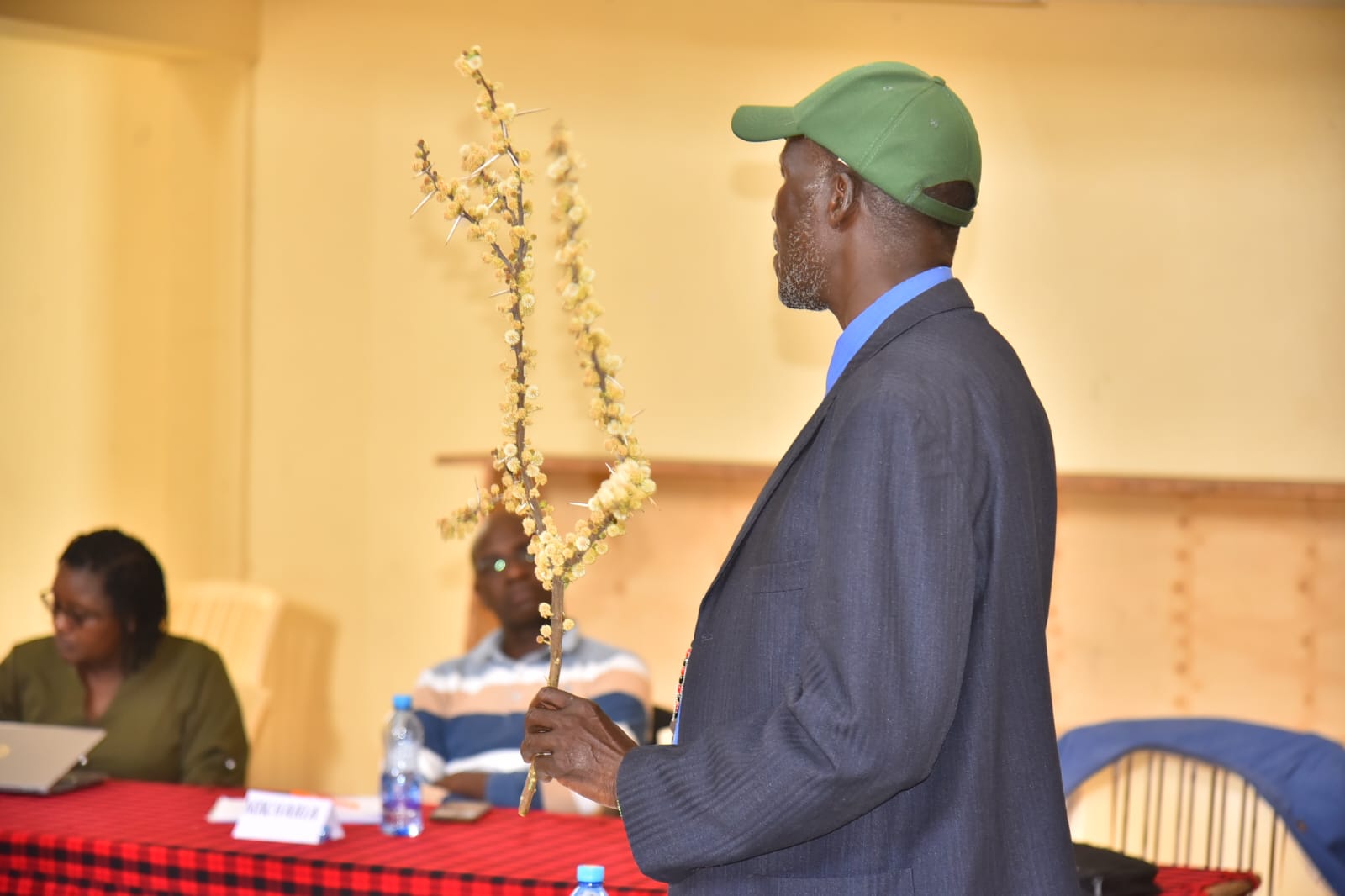 Mzee John ole Wuapari, one of the traditional experts on weather forecasting explains how they forecast the weather using the flowering of plants. Photo/Diana Meneto.