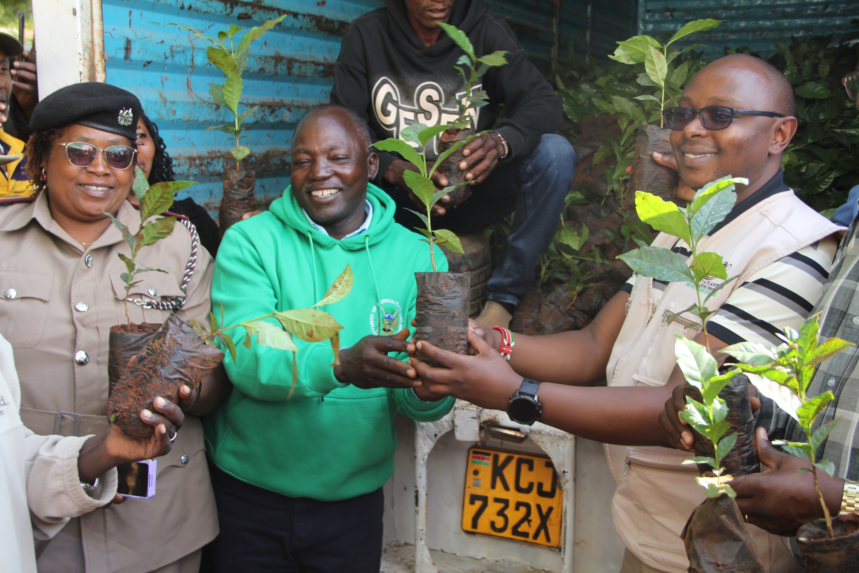 From right, Laikipia County Governor, Joshua Irungu, (clad with jumper) holds a coffee seedling during issuance to farmers in Kinamba 