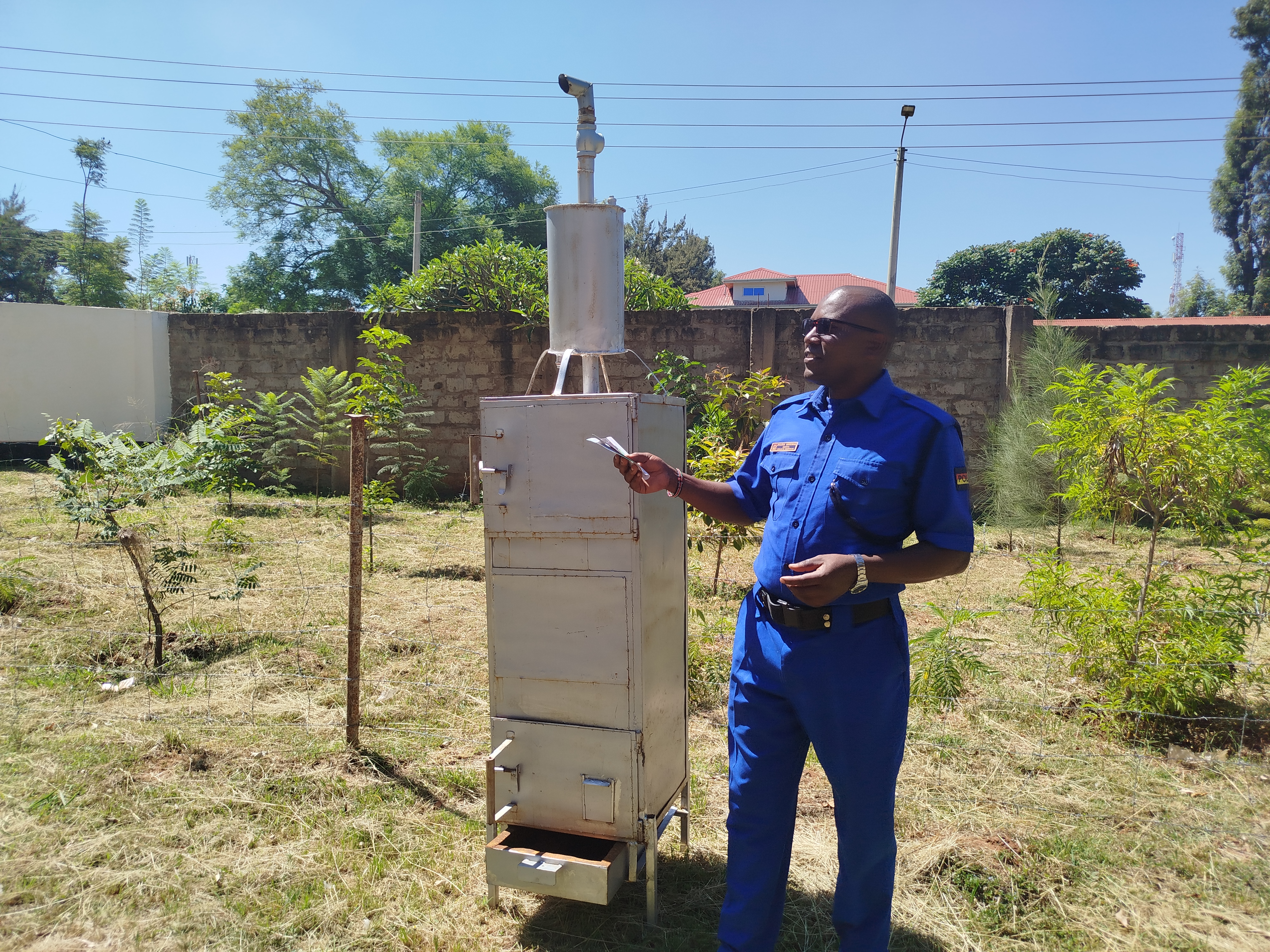 Julius Mwenda Police Environmentalist showcasing the 50kg Eco-friendly smokeless Incinerator that reduces carbon emission to the environment. Photo by Anne Kangero  