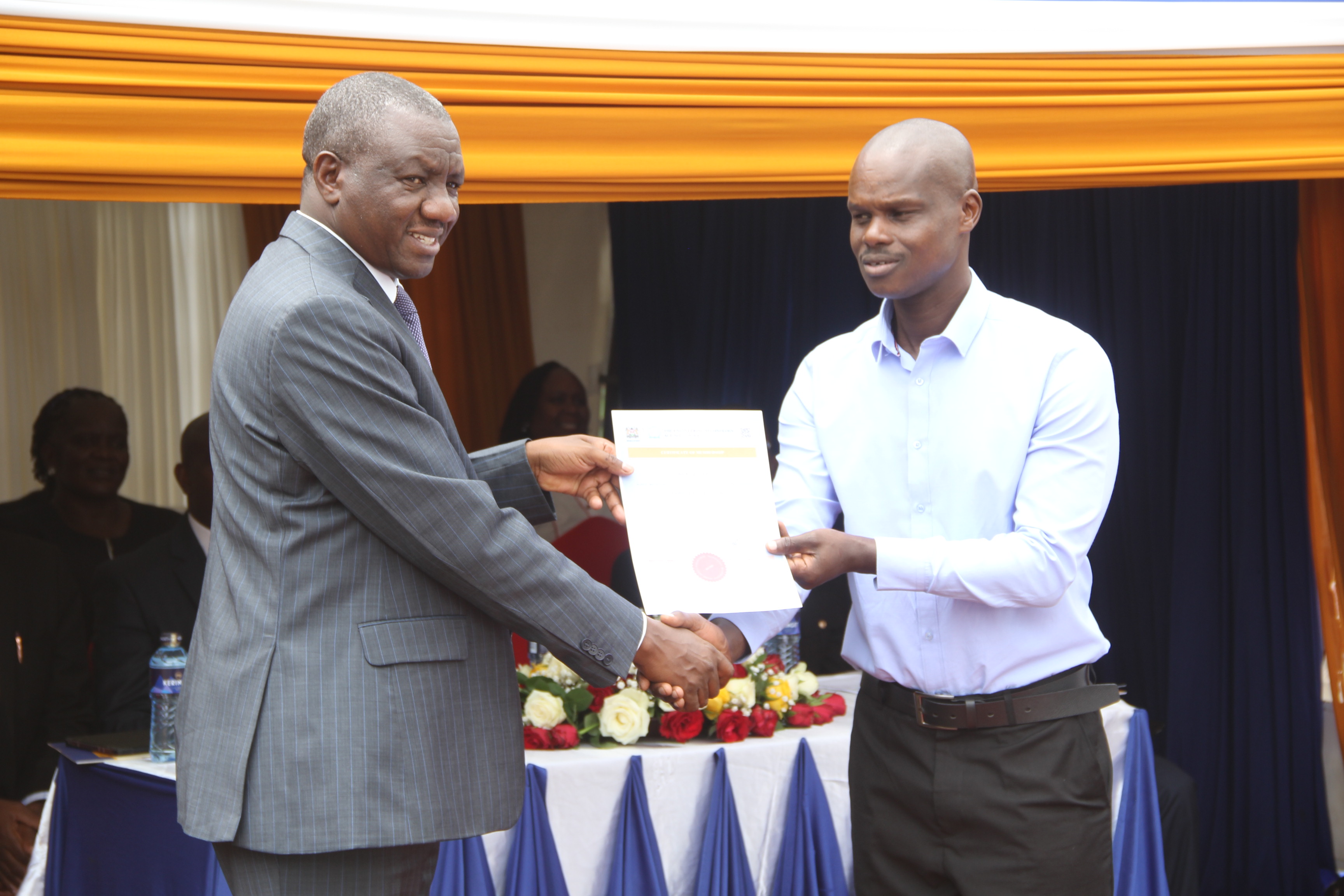 The Secretary, Human Resource Service, at the Ministry of Public Service and Human Capital Development, Dr. Jacob Mbijiwe, presented the Engineering Technologist certificate to Siele Edwin Kingetich, during the launch of the KTRB services at the Eldoret Huduma Centre