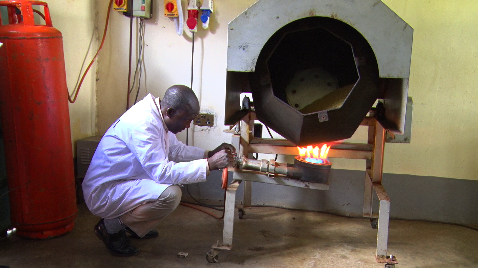 A Kenya Industrial Research Development Institute (KIRDI) official lighting up a dryer at the Migori KIRDI office; for drying soyabeans, groundnuts, sunflower, millet, sorghum and other cereals.