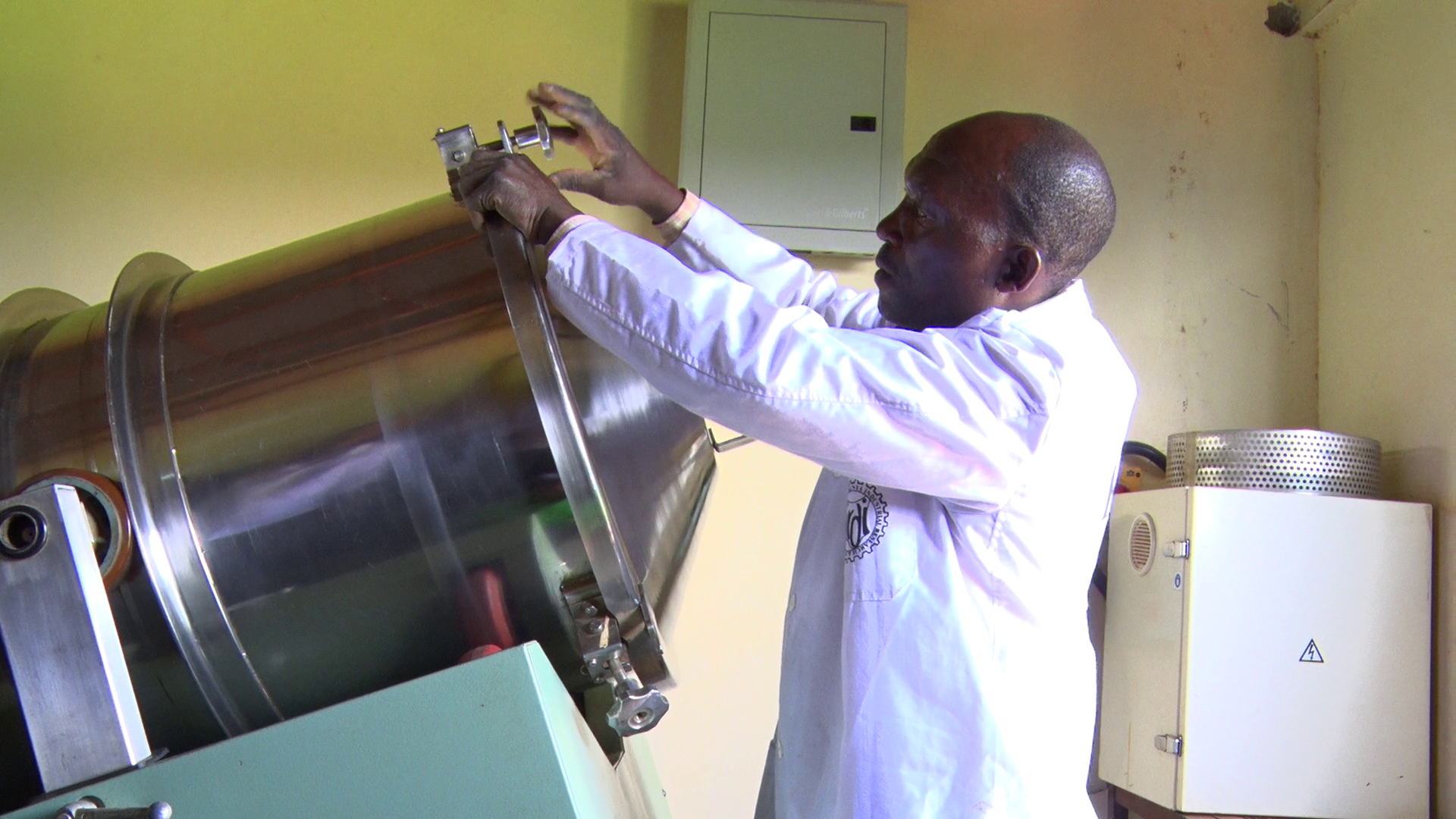 A Kenya Industrial Research Development Institute (KIRDI) official opens a mixer at the Migori KIRDI office. The mixer is used by scale farmers for mixing feed ingredients for animals, poultry and fish. Photo by Makokha Khaoya.