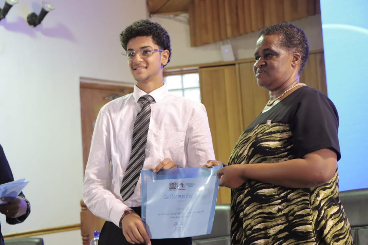 The Acting Chief Executive Officer of CEMASTEA, Gladys Masai (R), presents certificates to a participant