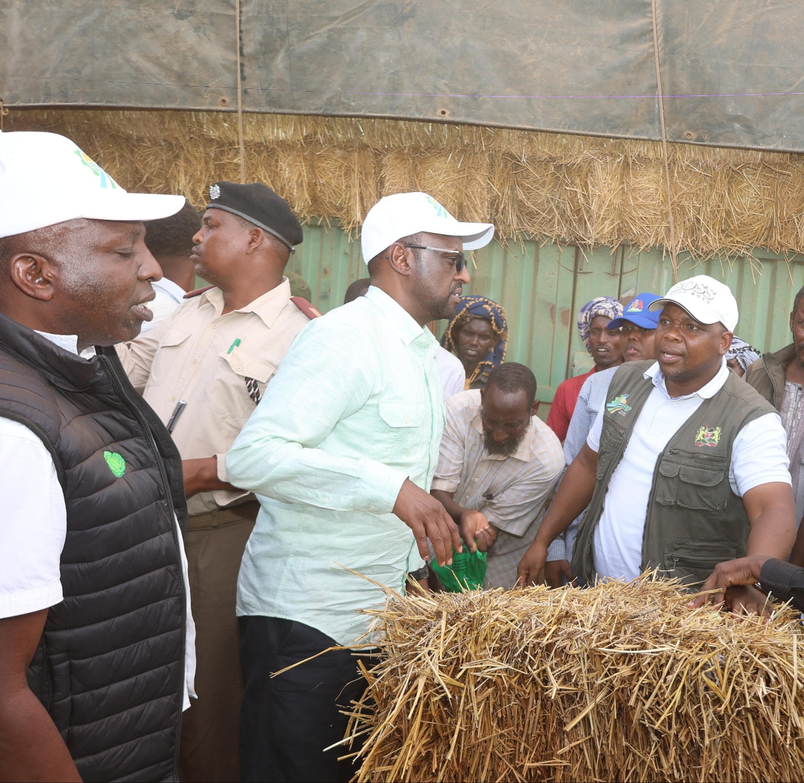  Mandera Deputy Governor Dr. Ali Maalim (centre) engages stakeholders during the launch of the Livestock Feed Subsidy Programme under the Food Systems Resilience Program (FSRP) in Banisa SubCounty, Mandera County. He is joined by Dr. Dominic Menjo (left) and Mr. Hillary Ngeno, as they inspect hay bales provided to support pastoralists in enhancing livestock survival and productivity amid drought conditions.