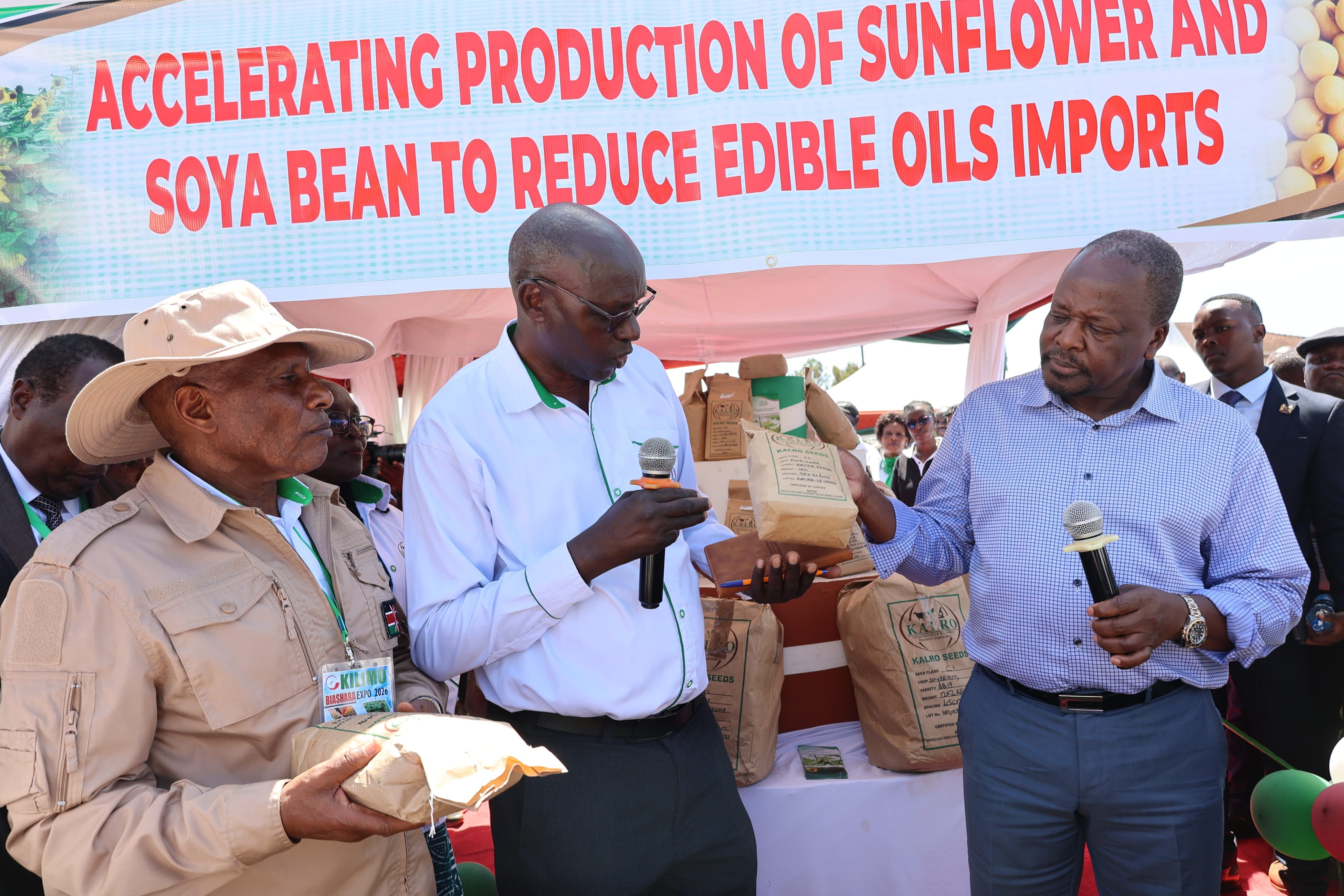 KALRO Board Chairman, Dr. Thuo Mathenge, James Njoroge, a scientist based at the KALRO Food Crops Research Center in Njoro and Cabinet Secretary Mutahi Kagwe at the Kilimo Expo showcasing edible oil crops seeds of sunflower and Soy.