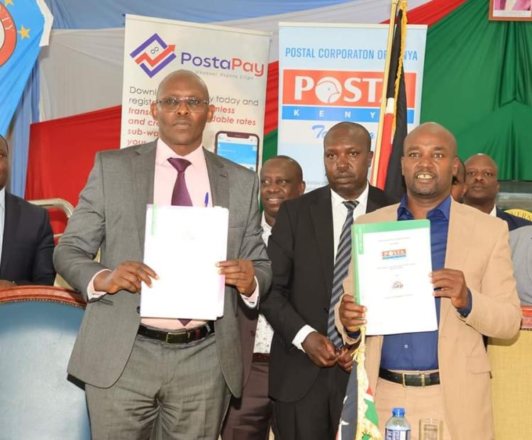 Bomet Governor Hillary Barchok (in Cream-Yellow suit) and Postal Corporation of Kenya Post Master General and Chief Executive Officer John Tonui Posing after signing a memorandum of Understanding (MOU at the county headquarters.