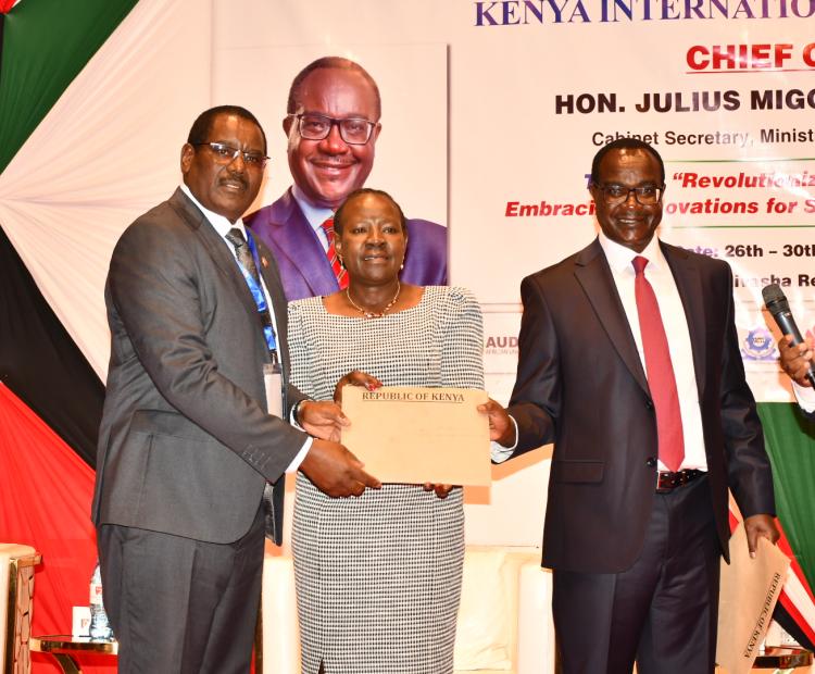 Ministry of Education Cabinet Secretary Julius Ogamba [right] with her counterpart PS in charge of TVETs Dr. Esther Muoria [center] hands over letters of deployment of trainers to Nyeri Technical Institute Principal David Mwangi who are part of 2,000 trainers the government  has dispatched to 242 TVET institutions to boost quality training in a ceremony held in Naivasha.