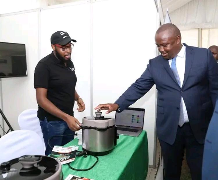 Exhibitors at the 5th edition of the clean cooking week expo explaining to the PS for Energy Anthony Wachira how their clean cooking innovations work. 