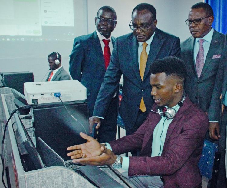 Henry Kivuva, a student at the Machakos Teachers College, takes Education Cabinet Secretary Julius Ogamba through a digital session with their new advanced computers during the launch of the Scaling Digital Skills program at the Machakos TTC. Photo by Steve Allan