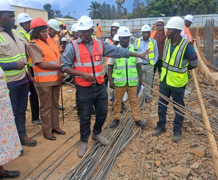 One of the Engineers showing the Principal Administrative Secretary Juliana Yiapan (L) some of the achievements they have had with the Affordable Housing Project at Lumumba site, Kisumu Central. Photo/Joseph Ouma