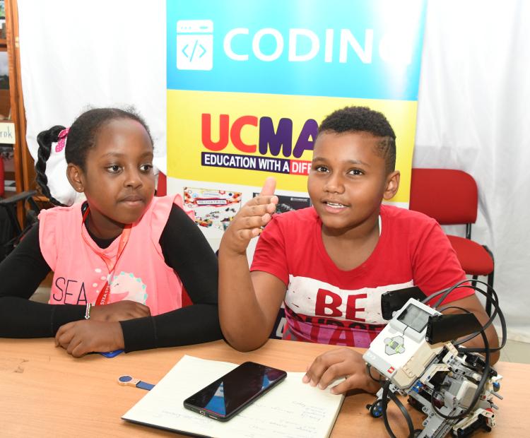 Giovanni Kei (R), who is a grade five student at St. Hannah's Nairobi and a grade four pupil at St. George Kiringatah, Nairobi, Kimberly Waringa, demonstrating how a smart puppy. Photo/Bonface Malinda