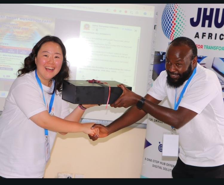 CEO of Mush & Co Jihyun Jung and founder of Jhub Lawrence Nderu exchanging gifts.