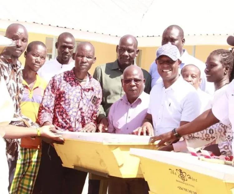 Principal Secretary for Agriculture Jonathan Mueke (third from right) accompanied by officers from State Department for Livestock during handing over of beehives to farmers in Turkana central and Loima sub county. PHOTO: PETER GITONGA 