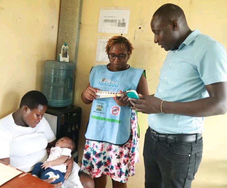 Kevin Kasadhe (right) demosntrates how the Bili Ruler works to a nurse at Jaramogi Oginga Odinga Teaching and Referral Hospitalon 