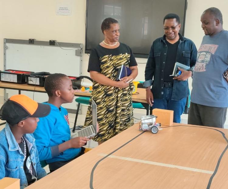 The Acting Chief Executive Officer of CEMASTEA, Gladys Masai (left standing), assesses a PID colour sensor project alongside National Trainer and Coordinator of the STEM Boot Camp at CEMASTEA, Mr. Martin Mungai (centre standing), and a STEM trainer (right), as learners showcase innovative solutions developed during a five-day STEM Boot Camp.