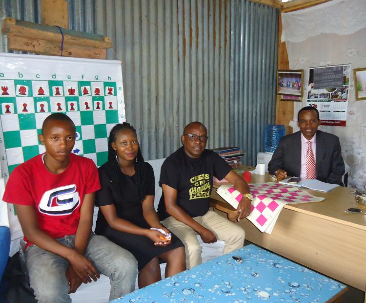 Chess player Jane Wangari (centre) poses with fellow player Stephen Gachuhi, (left) and their trainer, Josephat Kimani, (second right) Founder and Director of Chess Masters Club. PHOTO: ESTHER MBUTHIA