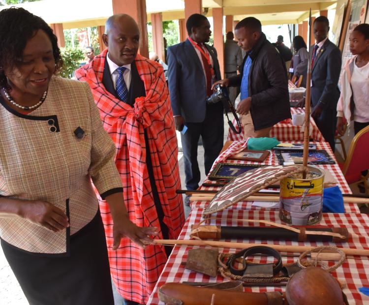 Maasai Mara University Vice Chancellor Prof. Peninah Oloo, left and KNIA CEO Dr. Tonny Omwansa, in a Maasai shuka in one of the students’ stands showcasing their innovative ideas during the Innovation week held at the Narok town campus, Narok Central Sub-County