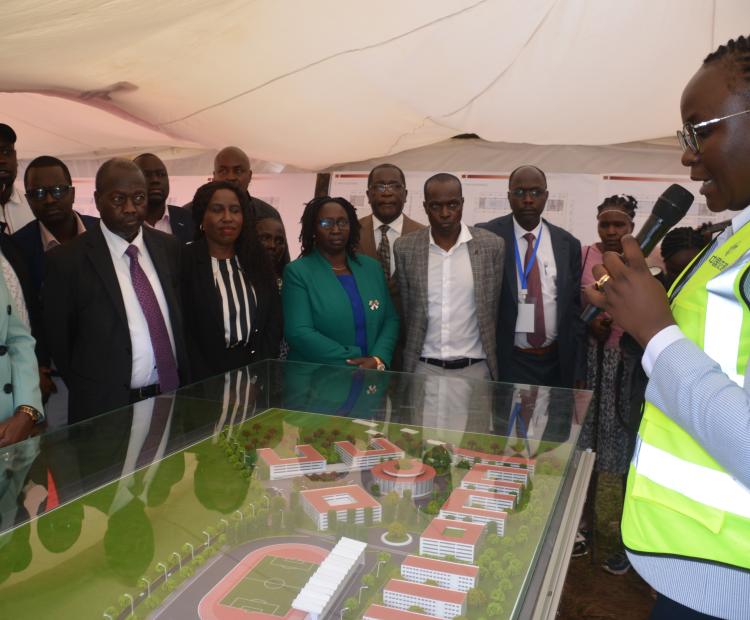 Defense Cabinet Secretary Soipan Tuya (left) is taken through the Kabarnet University College design model during the groundbreaking ceremony at the main campus grounds.