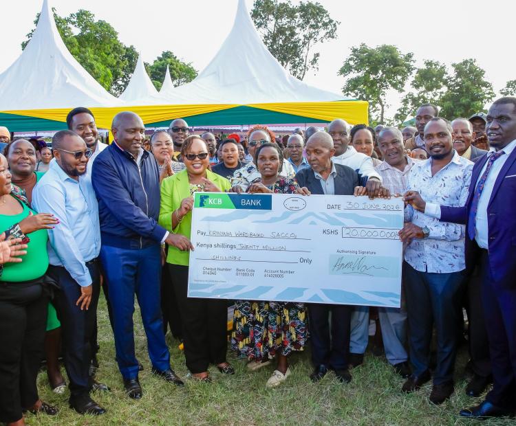 Kirinyaga County Governor Anne Waiguru (fourth from left), together with community group leaders and other Kirinyaga leaders, hold a dummy cheque during the issuance of empowerment funds to ward-based Saccos.