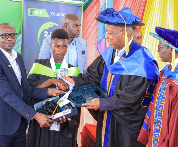 An electrical engineer graduate (second left) receiving a tool kit courtesy of KCB foundation from Governor Amos Nyaribo (second right) and KCB Foundation 2jiajiri Programmes Manager Joblin Omari (left). Looking on is Kisii University Vice Chancellor Prof. Nathan Ogechi (far right) during the trainees’ graduation at Sironga grounds. Photo: Deborah Bochere.  1 Attachment