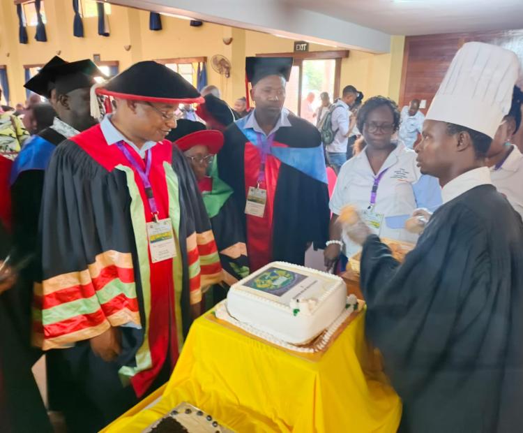  Director of TVET Dr. Joseph Kanyi (in red and black) inspects a cake decorated by one of the Recognition of Prior Learning graduates during the graduation ceremony at Kenya Coast National Polytechnic in Mombasa.
