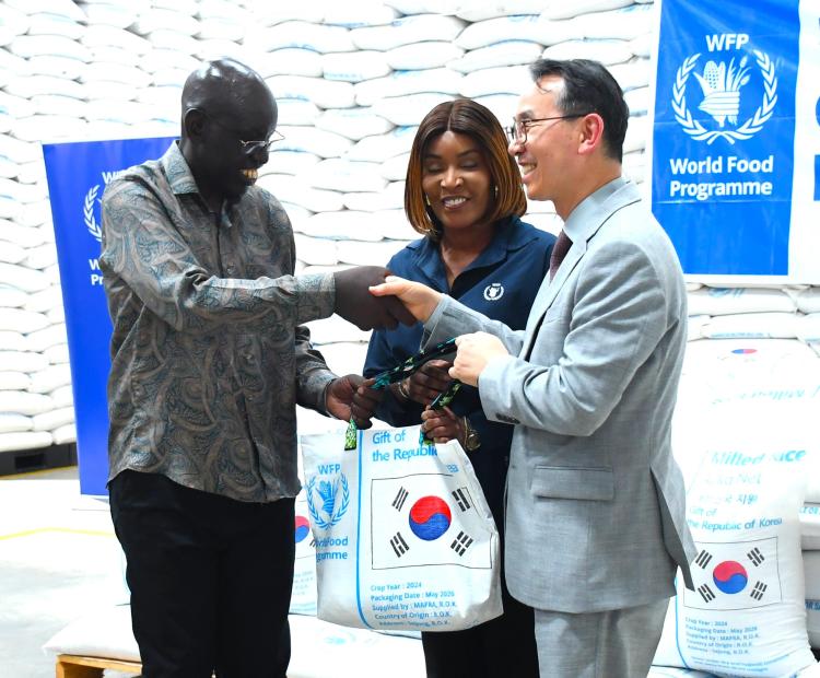 The Principal Secretary for Immigration and Citizen Services, Dr Belio Kipsang (left), receives a symbolic bag of rice from Ambassador of the Republic of Korea to Kenya, Kang Hyung-shik (R), as WFP Country Director, Ms Betty Ka (C) looks on, during the Korea-WFP rice handover ceremony held at the WFP offices, Mombasa.